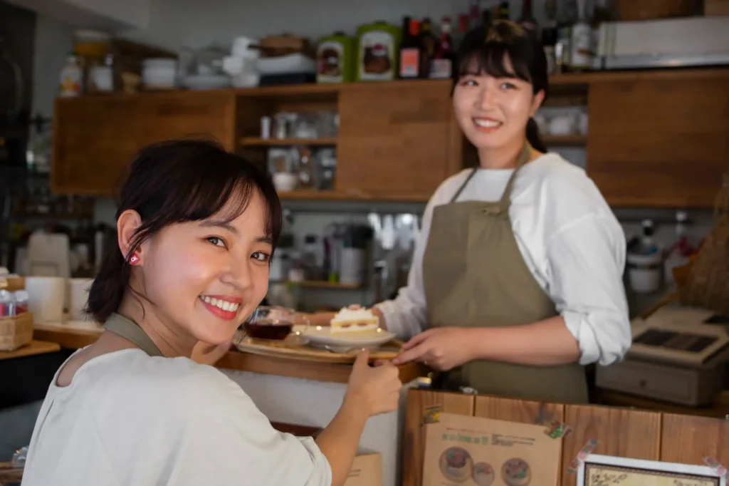 2 ladies smiling holding cake